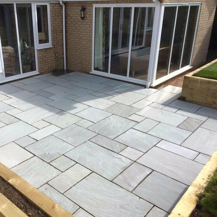 Light grey paved patio beside a rear extension