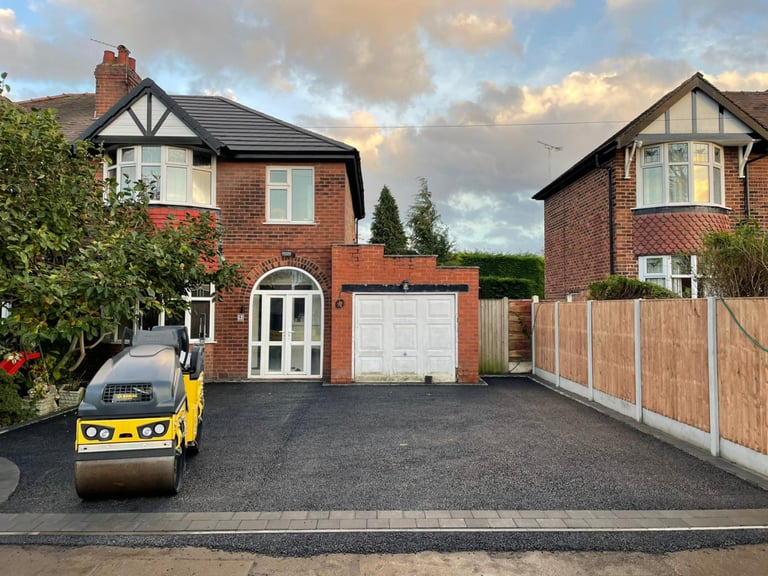 Freshly laid tarmac driveway with a roller and block paved entrance